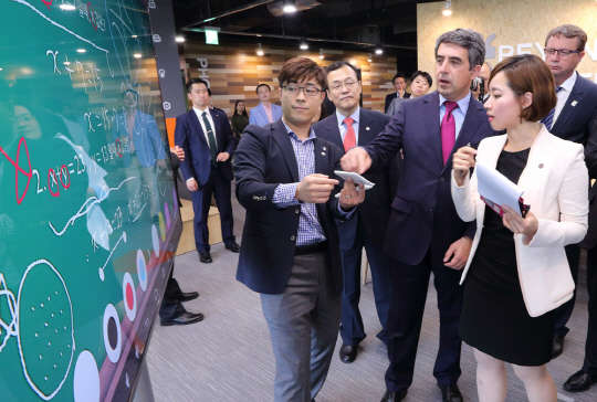 경기창조경제혁신센터는 해외 정상급으로는 처음으로 로젠 플레브넬리에프 불가리아 대통령이 방문해 센터 시설을 시찰하고 협력 양해각서(MOU)를 체결했다고 15일 밝혔다. 로젠 플레브넬리에프 대통령(가운데)이 경기도 판교에 위치한 경기창조경제혁신센터에 방문해 입주업체 애니랙티브 임성현 대표(왼쪽)의 전자칠판 서비스에 대한 설명을 듣고 있다. <KT 제공>